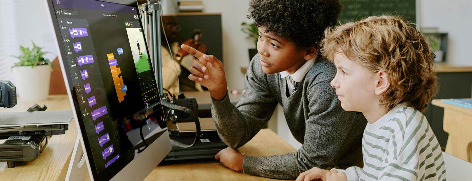 Two children are intently gazing at a computer screen, sharing a moment of curiosity and engagement.